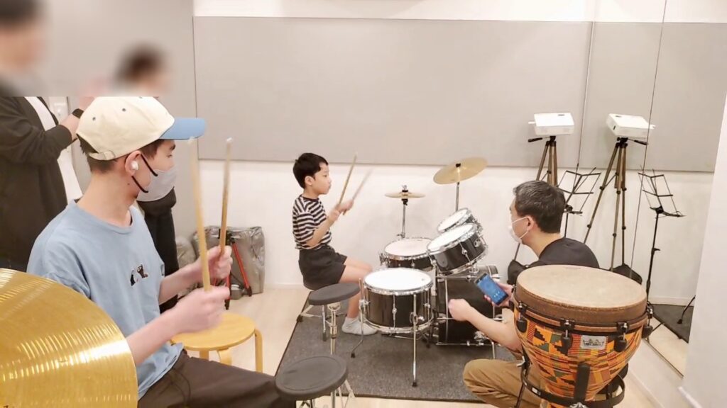 曲に合わせてドラム練習をしているシーン